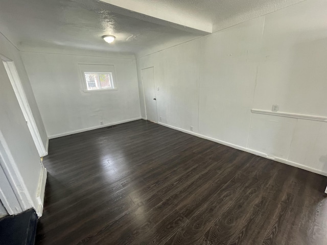 301 Michigan Ave, Bay City, MI 48708 - unfurnished room with baseboards, a textured ceiling, and dark wood-type flooring