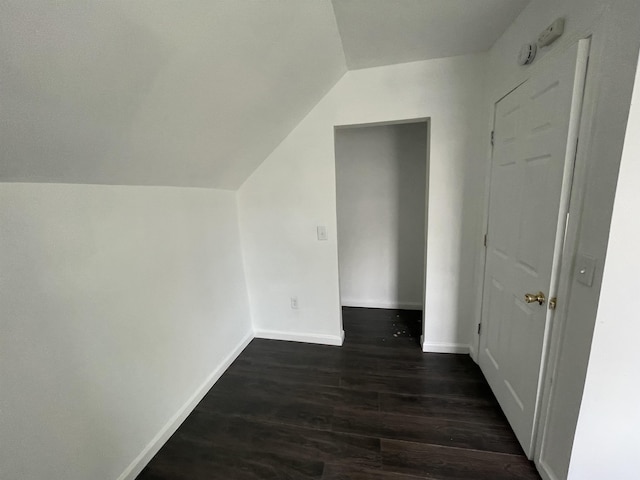 301 Michigan Ave, Bay City, MI 48708 - additional living space with vaulted ceiling, dark wood-style flooring, and baseboards