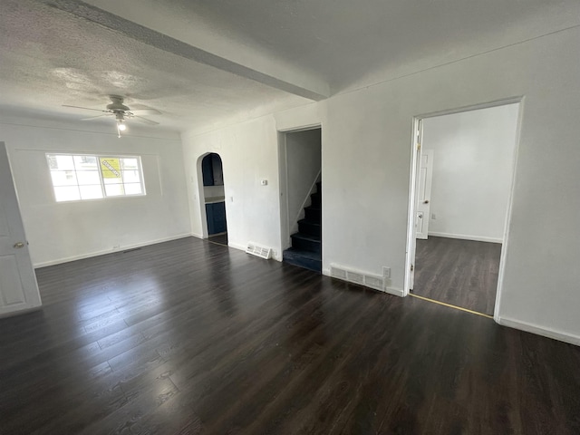 301 Michigan Ave, Bay City, MI 48708 - unfurnished living room featuring ceiling fan, visible vents, dark wood-type flooring, arched walkways, and stairway