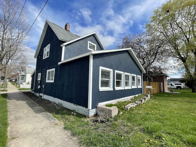 301 Michigan Ave, Bay City, MI 48708 - view of property exterior with a yard, a chimney, and fence