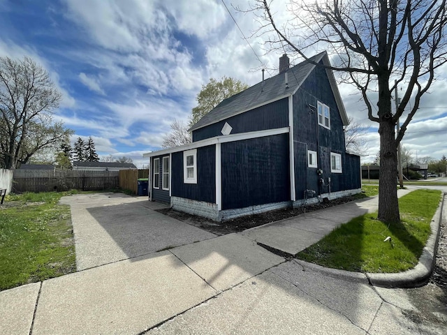 301 Michigan Ave, Bay City, MI 48708 - view of property exterior featuring fence, a chimney, and driveway