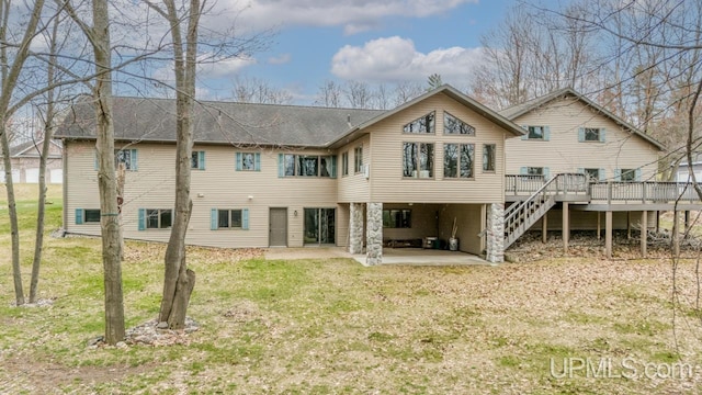 rear view of house featuring a lawn, a patio area, a wooden deck, and stairs