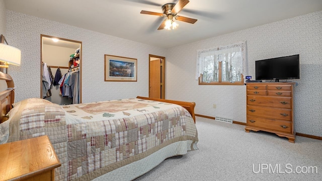 bedroom featuring a closet, visible vents, ceiling fan, a spacious closet, and carpet flooring