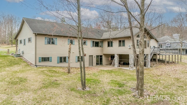 back of house with central air condition unit, a patio, roof with shingles, and a lawn