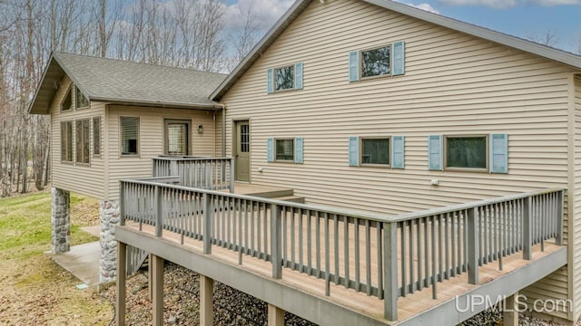 back of house featuring a deck and a shingled roof