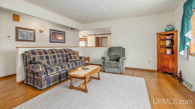 living area with baseboards and wood finished floors