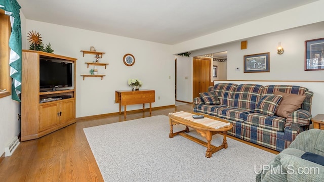 living area featuring baseboards and wood finished floors