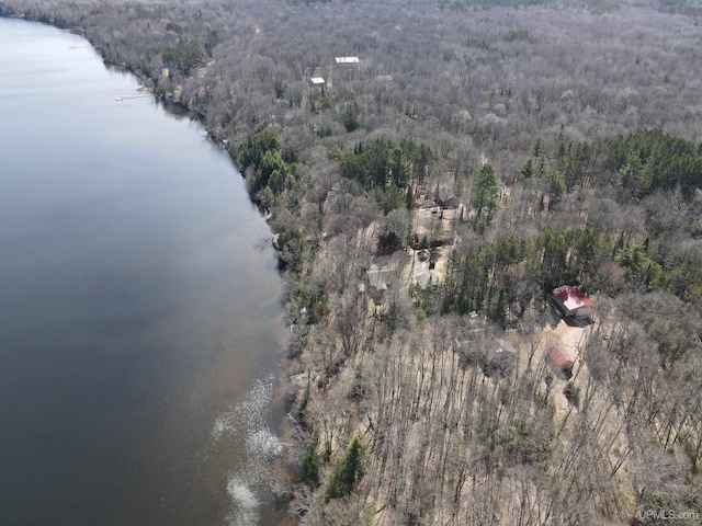 aerial view featuring a wooded view and a water view