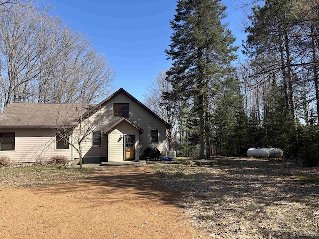 view of front of property featuring dirt driveway and central air condition unit