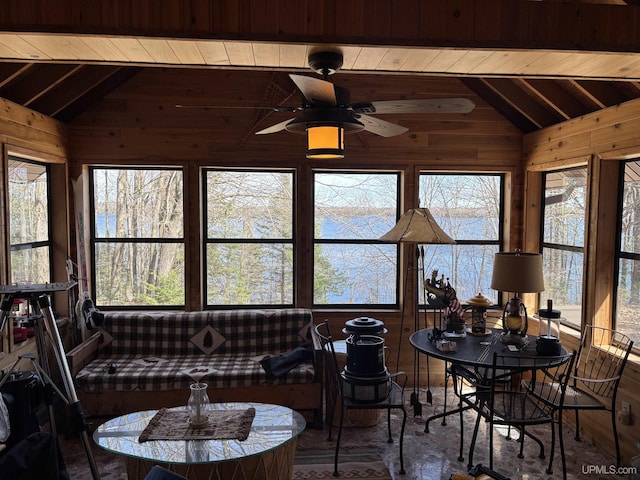 sunroom / solarium featuring lofted ceiling, wood ceiling, wooden walls, and ceiling fan