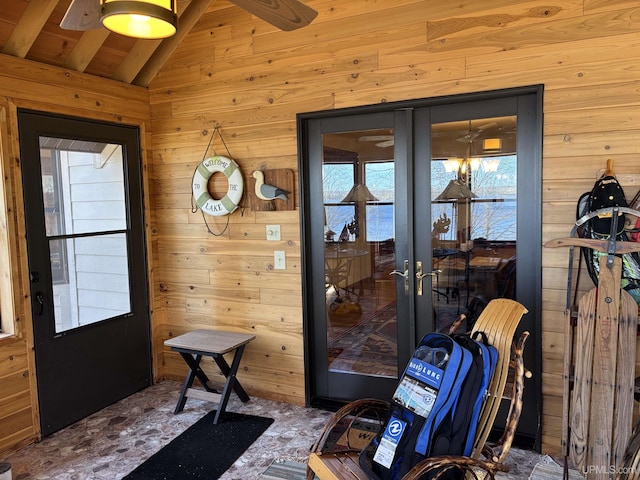 entryway featuring wood walls, french doors, and carpet floors