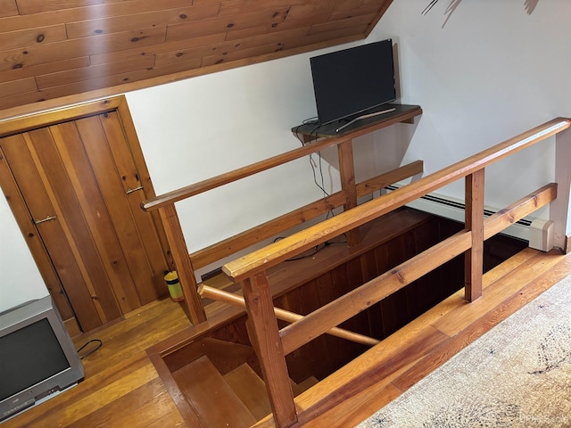 staircase with hardwood / wood-style floors, lofted ceiling, and wooden ceiling