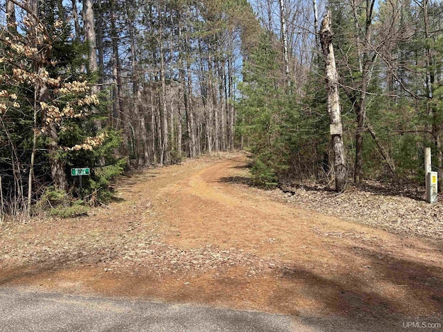 view of road featuring a forest view