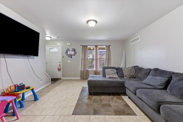 living area featuring baseboards, visible vents, and light tile patterned flooring