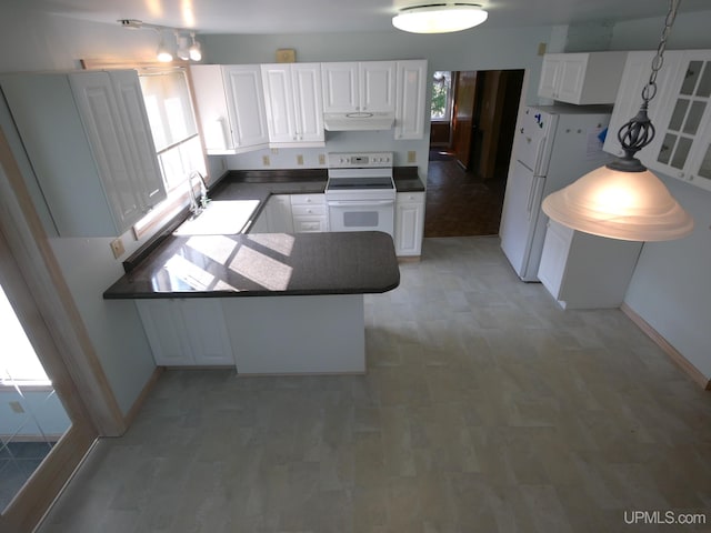 kitchen with a sink, a peninsula, white appliances, under cabinet range hood, and white cabinetry