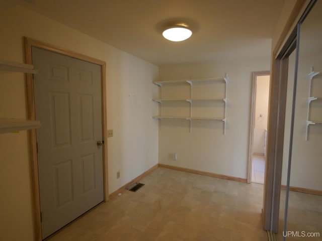 interior space featuring light floors, baseboards, and visible vents