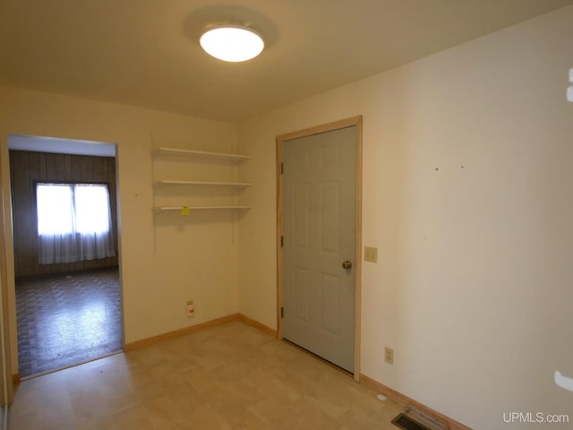 unfurnished room featuring light floors, visible vents, and baseboards