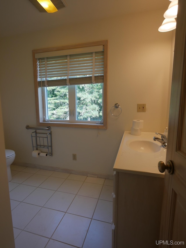 bathroom with vanity, toilet, and baseboards