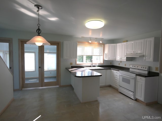 kitchen with under cabinet range hood, dark countertops, white range with electric stovetop, and white cabinetry