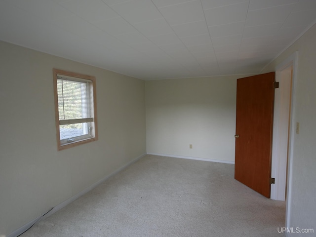 empty room featuring carpet and baseboards
