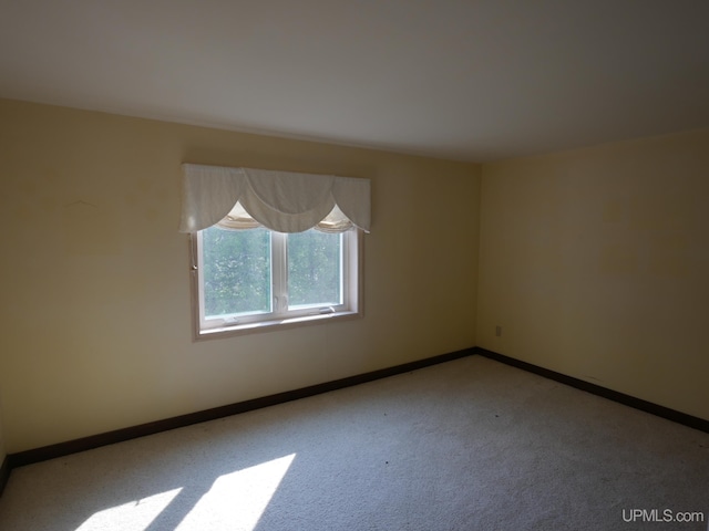 carpeted empty room with baseboards