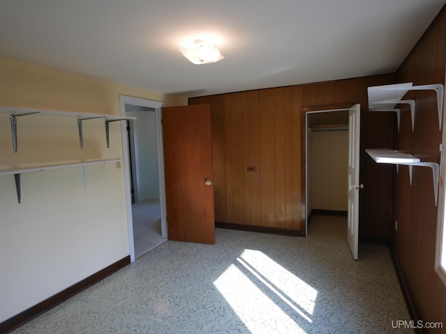 unfurnished bedroom with wooden walls and baseboards