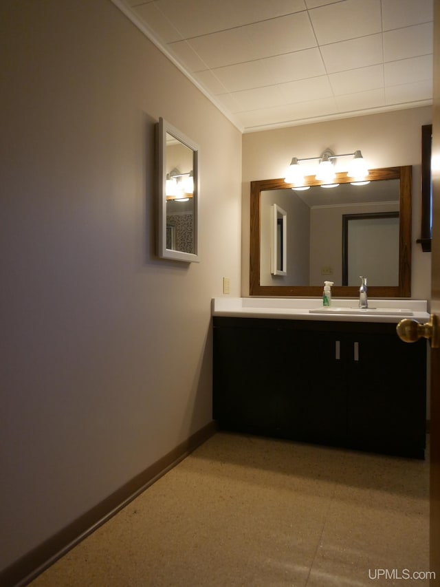 bathroom with baseboards, vanity, and crown molding