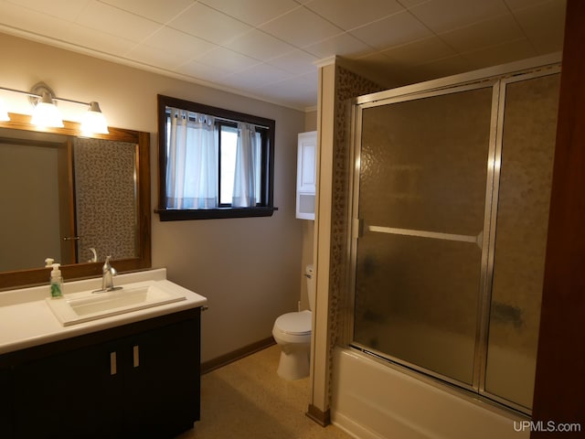 bathroom featuring toilet, baseboards, bath / shower combo with glass door, vanity, and crown molding