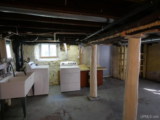 basement featuring washer and clothes dryer and a sink