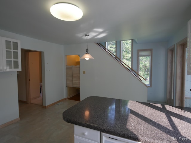 kitchen featuring glass insert cabinets, light wood-style flooring, white cabinetry, visible vents, and decorative light fixtures