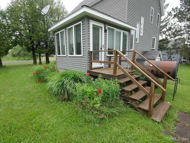 exterior space featuring a wooden deck and a lawn