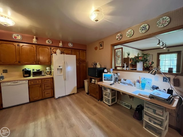 kitchen with brown cabinetry, white appliances, light countertops, and light wood-style flooring