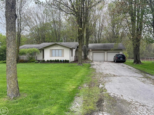 ranch-style home featuring a front yard, aphalt driveway, and an attached garage