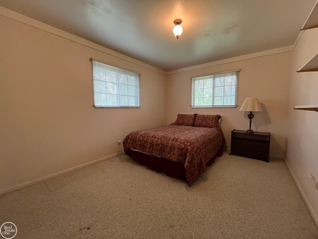 bedroom with baseboards, ornamental molding, and carpet floors