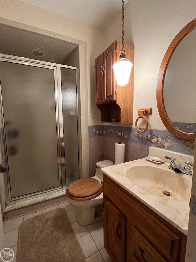 bathroom with toilet, a stall shower, wallpapered walls, tile patterned floors, and vanity