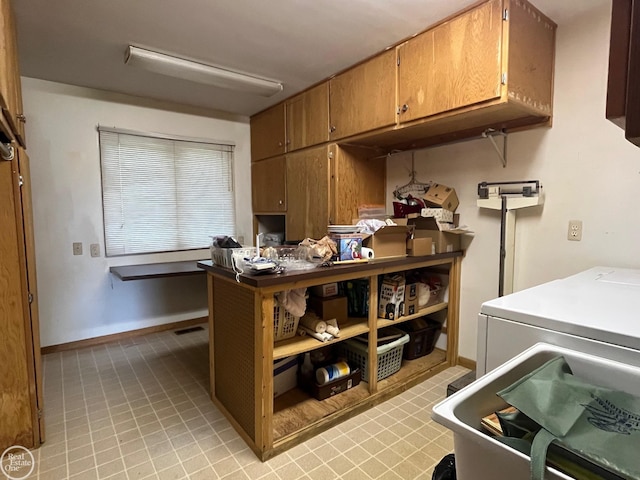 kitchen with washer / clothes dryer, brown cabinetry, light countertops, and baseboards