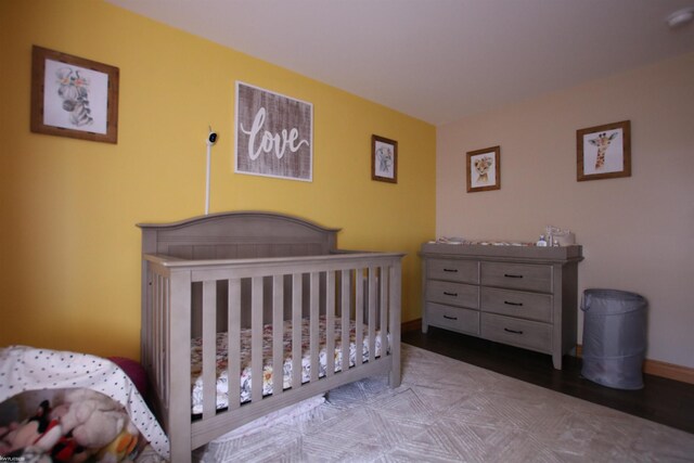 bedroom featuring a crib and baseboards