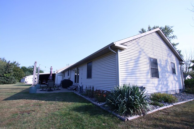 view of property exterior featuring a patio and a lawn