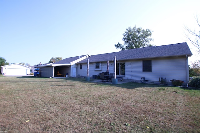rear view of house with a patio area, a yard, and roof with shingles