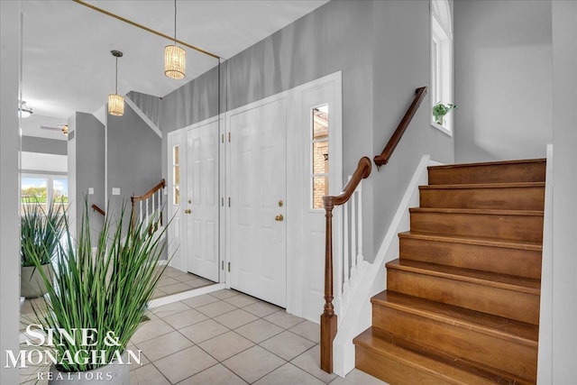 foyer entrance with stairway and light tile patterned flooring
