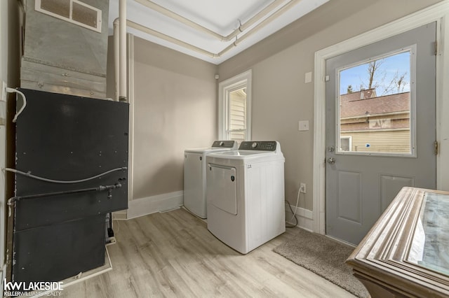 washroom with baseboards, visible vents, washer and clothes dryer, laundry area, and light wood-type flooring