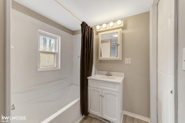 bathroom with baseboards, vanity, and bathtub / shower combination