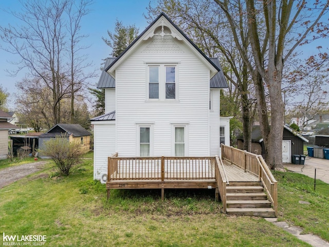 back of house featuring a yard, metal roof, and a wooden deck