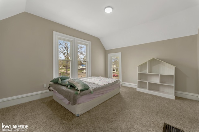 bedroom with carpet, visible vents, baseboards, and lofted ceiling