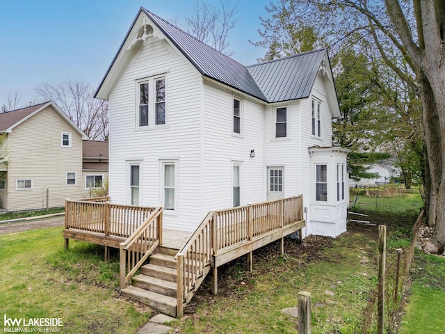 rear view of property featuring metal roof and a wooden deck