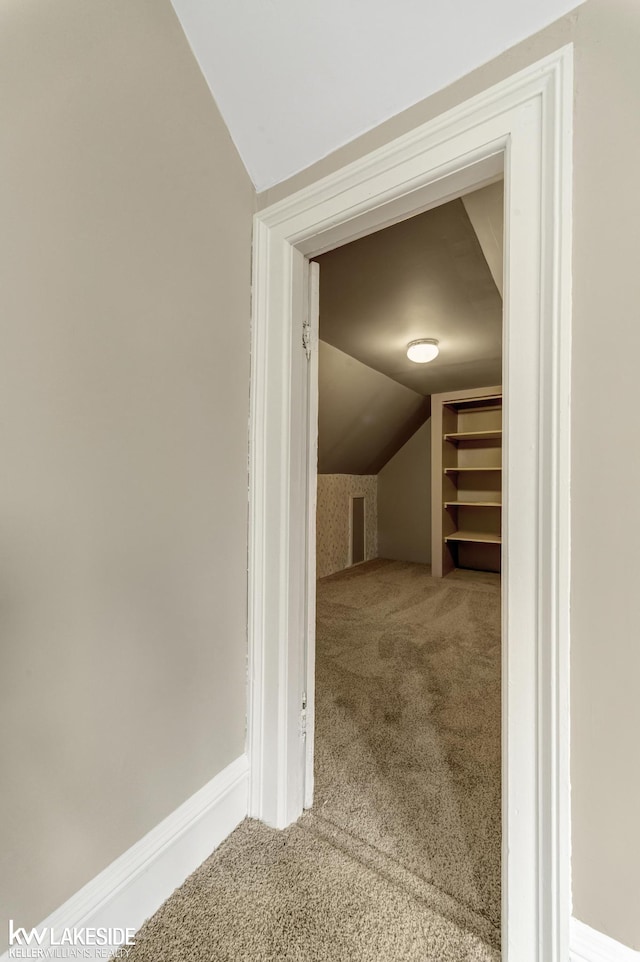 interior space featuring carpet flooring and vaulted ceiling