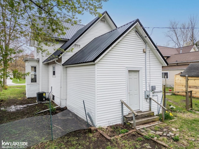 rear view of house featuring metal roof and entry steps