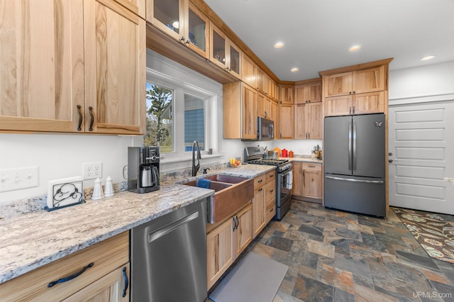 kitchen featuring glass insert cabinets, stone finish flooring, stainless steel appliances, light stone counters, and recessed lighting