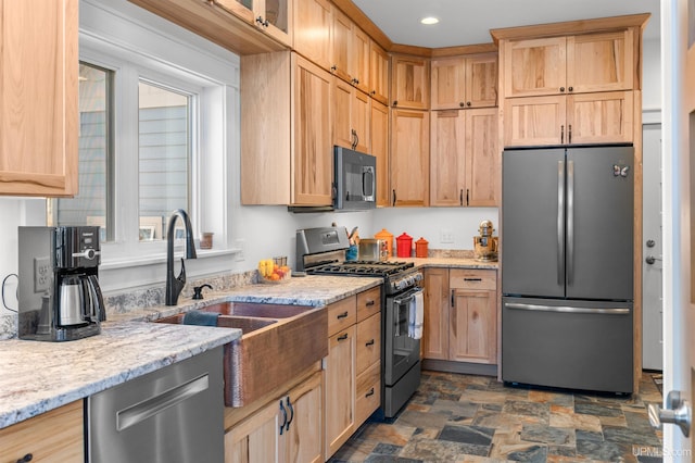 kitchen with stone finish flooring, light brown cabinets, appliances with stainless steel finishes, light stone counters, and recessed lighting