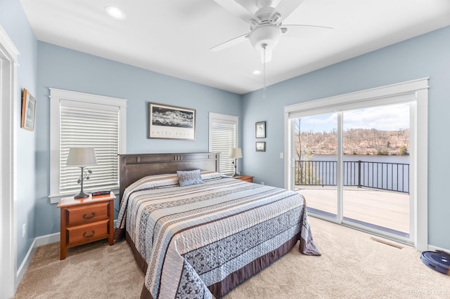 carpeted bedroom with baseboards, ceiling fan, visible vents, a water view, and access to outside